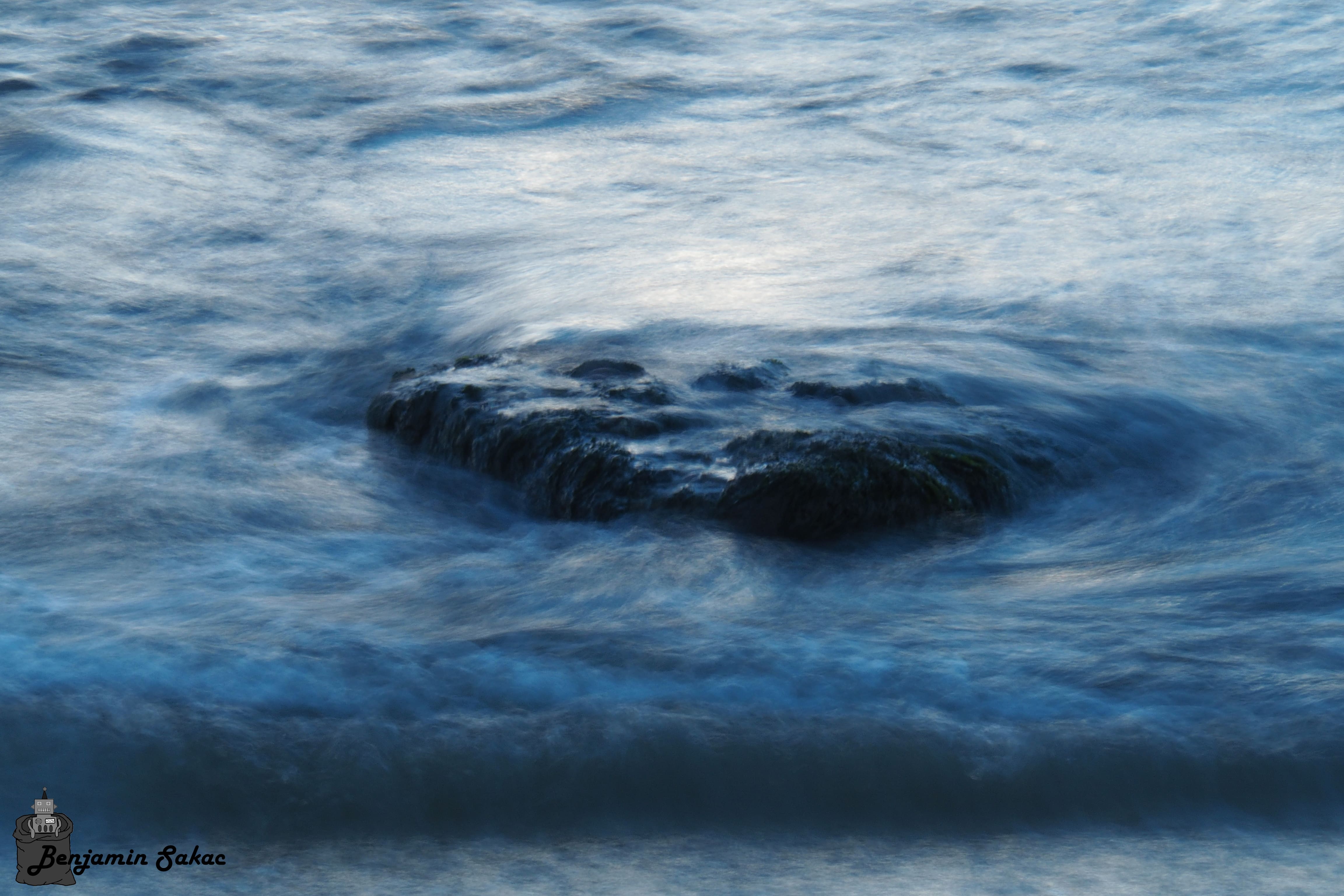 Wave washing over rock on the shore